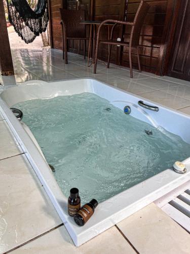 a jacuzzi tub filled with water with two bottles in it at Verde Mar Pipa Beach in Pipa