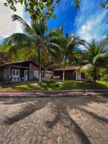 a house with palm trees in front of a driveway at Verde Mar Pipa Beach in Pipa