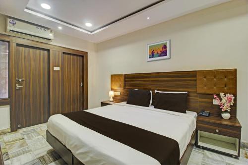 ein Schlafzimmer mit einem großen Bett und einem Kopfteil aus Holz in der Unterkunft OYO Hotel Srujana Stay Inn Opp Public Gardens Nampally in Hyderabad