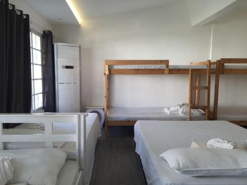 Cette chambre comprend deux lits superposés et un réfrigérateur. dans l'établissement KUROSHARA Beach Resort, à Bolinao