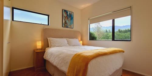 a bedroom with a bed and a large window at Lakeside Retreat in Cromwell
