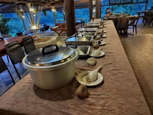 een lange tafel met een pot en borden erop bij Balai Serama Guesthouse in Kuala Tahan