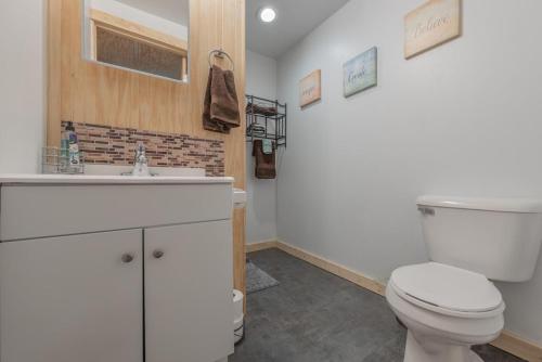 La salle de bains est pourvue de toilettes blanches et d'un lavabo. dans l'établissement Tiny House at Buffalo River Lodge, à Saint Joe