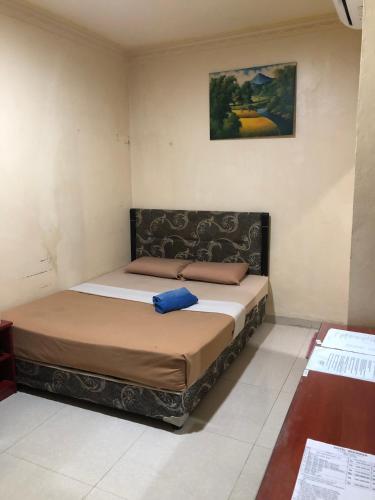 a bedroom with a bed with a blue pillow on it at Hotel Sekawan in Jodoh