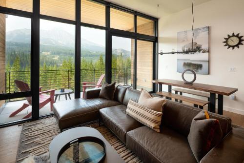 een woonkamer met een bank en een tafel bij 225 LakeLodge by Moonlight Basin Lodging in Big Sky