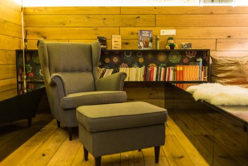 a room with two chairs and a book shelf with books at Nala Individuellhotel in Innsbruck