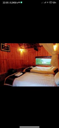 a bedroom with a large white bed with a window at Dao Homestay in Hoàng Su Phì