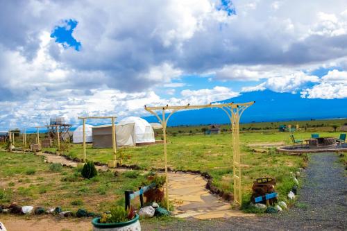 a field with a tent in the middle of a field at Amanya 1-Bed Zebra Tent in Amboseli