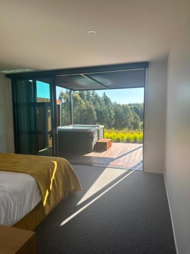 a bedroom with a bed and a view of a garden at Harakeke Boutique Accommodation in Mahana