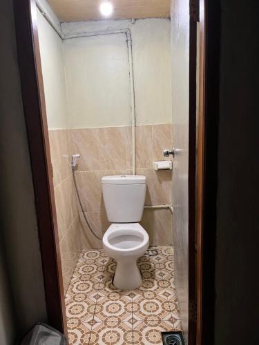 a bathroom with a white toilet in a stall at Bali Sunrise Camp & Glamping in Kintamani