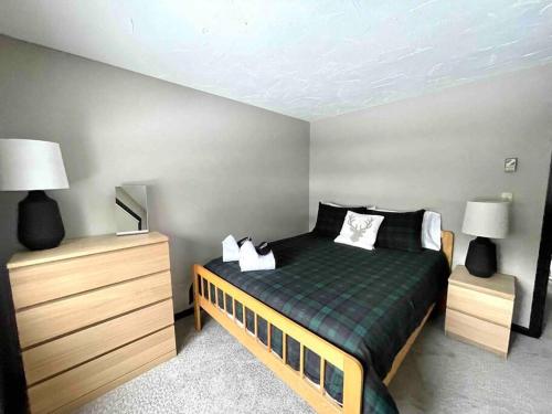 a bedroom with a bed and two night stands at Cozy Condo in the Woods (5 mins to Loon Mountain) in Lincoln