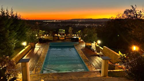 a swimming pool with a sunset in the background at Villa Somlyó in Fót