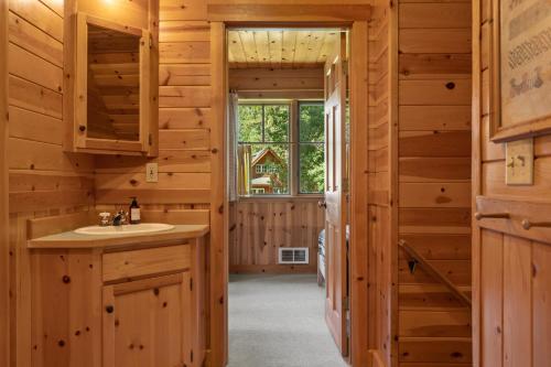 Camp ShermanにあるMetolius Cabin 12のバスルーム(洗面台、窓付)が備わるログキャビンです。