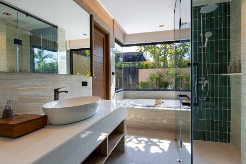 a bathroom with a tub and a sink and a shower at De Malee Pool Villas - SHA Extra Plus in Ao Nang Beach