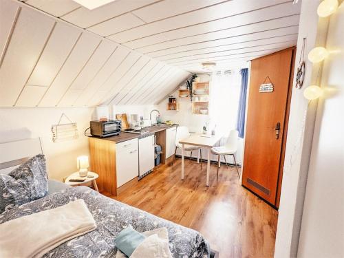 Zimmer mit einem Bett und einer Küche mit einem Tisch in der Unterkunft Urlaubsmagie - Kleiner Wohlfühlort mit Pool - H4 in Sebnitz