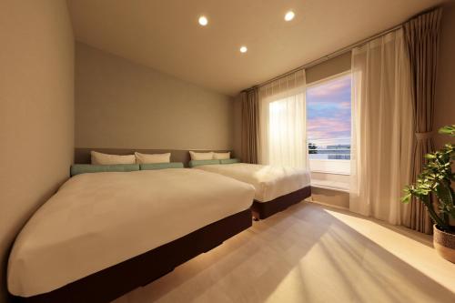 a bedroom with two beds and a large window at クリスタルヴィラ白良浜ビーチ in Kanayama