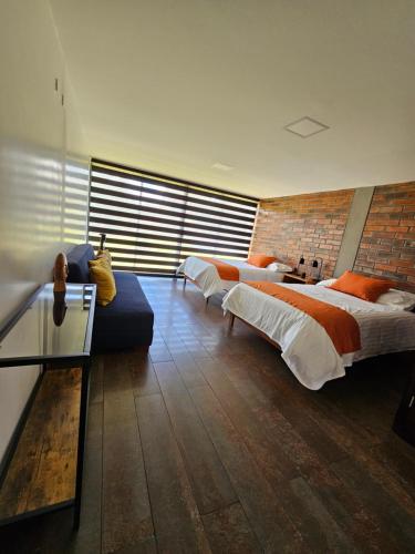 a bedroom with two beds and a couch at El Chasqui Guest House in Chasqui