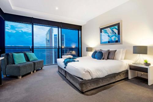um quarto com uma cama, uma cadeira e uma janela em Circle on Cavill - Sub Penthouse - Self Contained, Privately Managed em Gold Coast