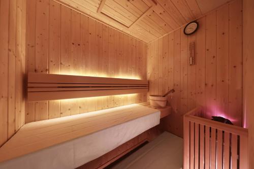 a sauna with a bench and a clock on the wall at クリスタルヴィラ白良浜ビーチ in Kanayama