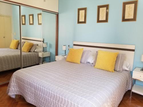 um quarto com uma cama grande e almofadas amarelas em Corazón Porteño em Buenos Aires
