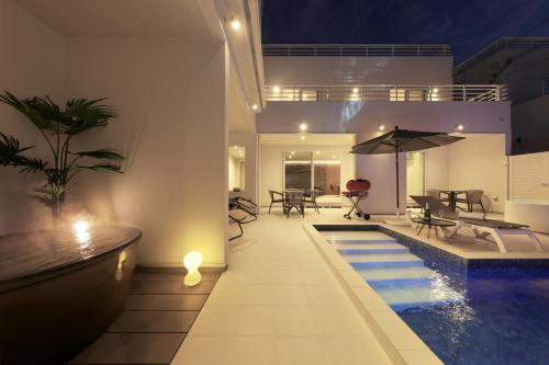 a house with a swimming pool and an umbrella at クリスタルヴィラ白良浜ビーチ in Kanayama