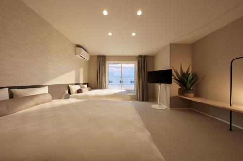 a hotel room with two beds and a window at クリスタルヴィラ白良浜ビーチ in Kanayama