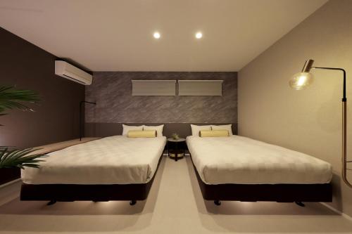 two beds in a small room with at クリスタルヴィラ白良浜ビーチ in Kanayama