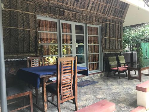 a dining room with a blue table and chairs at Marari Dreamz Homestay in Mararikulam
