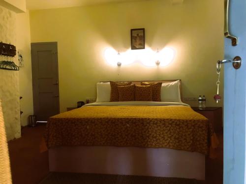 a bedroom with a bed with two lights on the wall at Marari Dreamz Homestay in Mararikulam