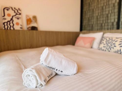 a folded towel sitting on top of a bed at 南灣陽光皮小妞 Pii hostel in Nanwan