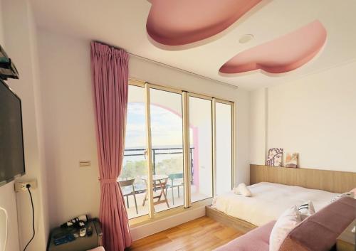 a bedroom with a bed and a large window at 南灣陽光皮小妞 Pii hostel in Nanwan
