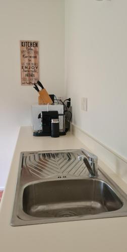 a kitchen counter with a sink and a microwave at Lakeside Retreat in Cromwell