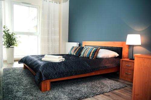 a bedroom with a bed with two towels on it at Livin Apartments Santocka in Szczecin