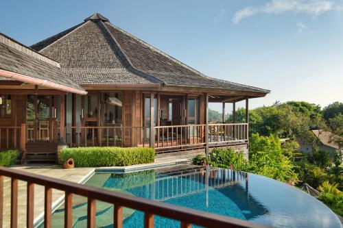a villa with a swimming pool and a house at Sempiak Seaside Resort in Selong Belanak