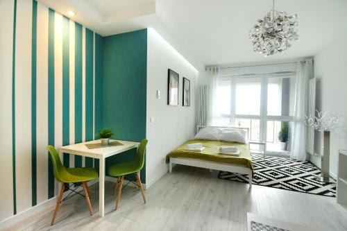 a bedroom with a bed and a table and chairs at Livin Apartments Santocka in Szczecin