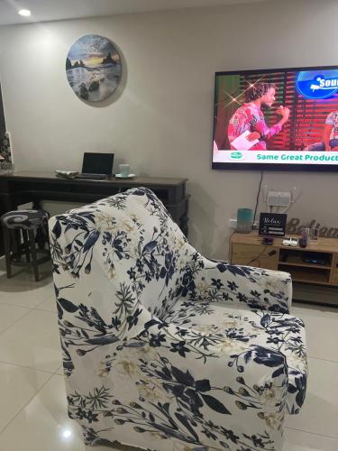 a living room with a chair and a tv at Bayfront Villa & Apartment in Portmore