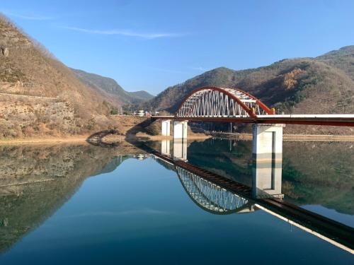 a bridge over a river with its reflection in the water at Danyang Rio 127 Guesthouse River View in Danyang