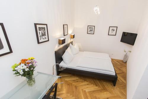 a small room with a bed and a glass table at Carlton Suites in Vienna