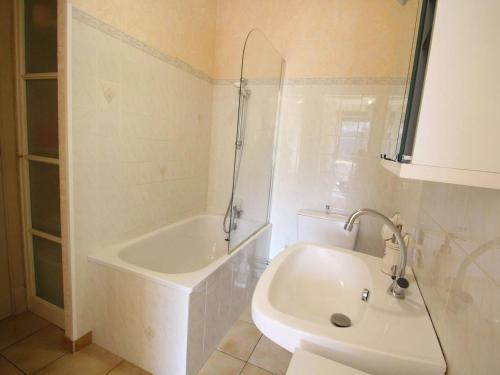 a white bathroom with a tub and a sink at Appartement Bagnères-de-Luchon, 3 pièces, 4 personnes - FR-1-313-228 in Luchon