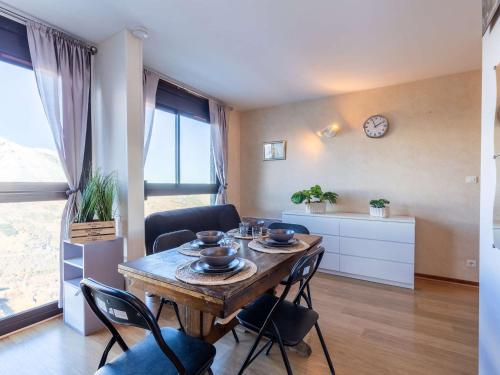 - un salon avec une table, des chaises et une horloge dans l'établissement Studio rénové 6 pers proche des pistes à Saint-Lary-Soulan - FR-1-296-483, à Saint-Lary-Soulan