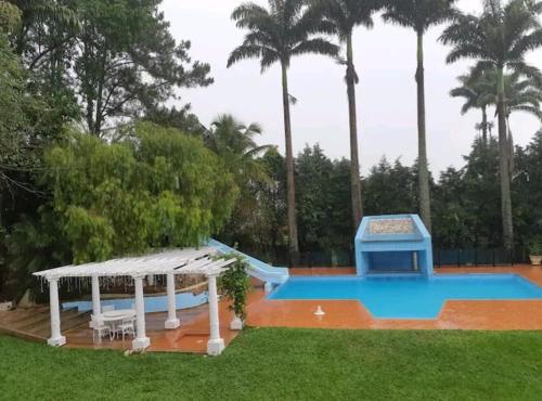 een zwembad met een glijbaan en een prieel bij Terra Rica Summer House in São Pedro