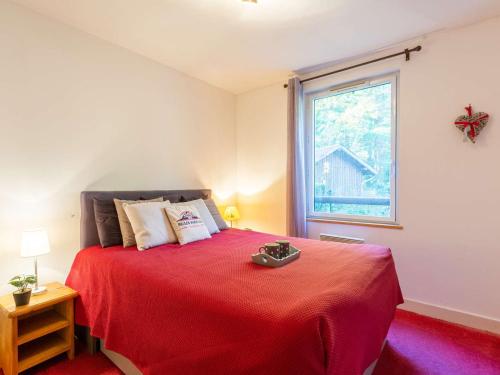 - une chambre avec un lit rouge et une fenêtre dans l'établissement Appartement 4 pers à Vielle Aure avec piscine, parking, proche du centre et des remontées - FR-1-296-482, à Vielle-Aure