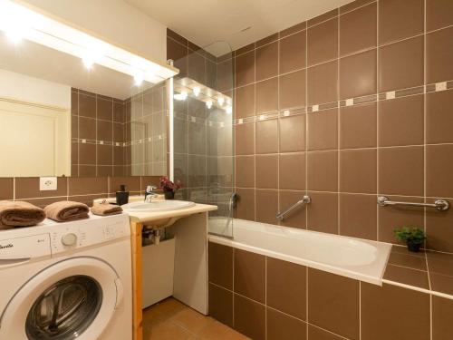 une salle de bain avec un lave-linge et une baignoire dans l'établissement Appartement 4 pers à Vielle Aure avec piscine, parking, proche du centre et des remontées - FR-1-296-482, à Vielle-Aure