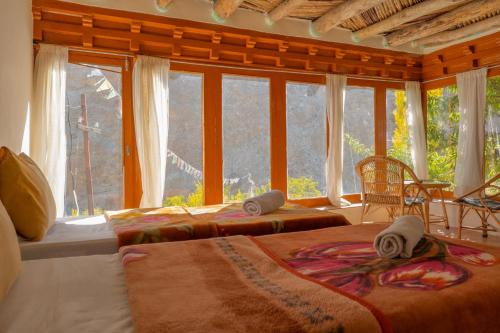 a bedroom with two beds and a large window at Garkone Homestay in Dah