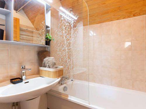 une salle de bain avec un lavabo, une baignoire et une douche dans l'établissement Duplex 3 chambres près de Saint Lary pour 6 personnes - FR-1-296-484, à Saint-Lary-Soulan