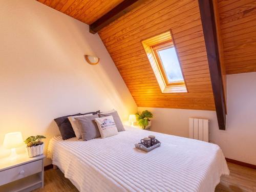 - une chambre avec un lit blanc et un plafond en bois dans l'établissement Duplex 3 chambres près de Saint Lary pour 6 personnes - FR-1-296-484, à Saint-Lary-Soulan