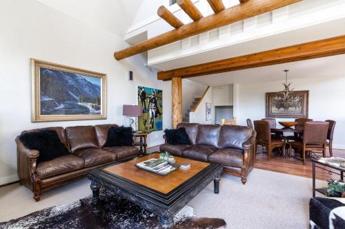 a living room with leather couches and a table at Saddle Ridge V2 by Moonlight Basin Lodging in Big Sky