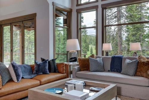 a living room with two couches and windows at 6 Diversion Lane by Moonlight Basin Lodging in Big Sky