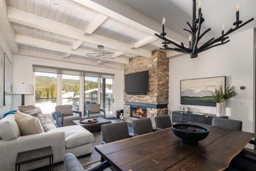 a living room with a table and a fireplace at 16 Wildwood by Moonlight Basin Lodging in Big Sky
