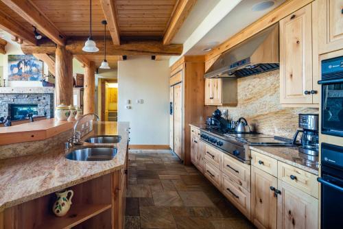 a kitchen with wooden cabinets and a sink at Penthouse 4 by Moonlight Basin Lodging in Big Sky